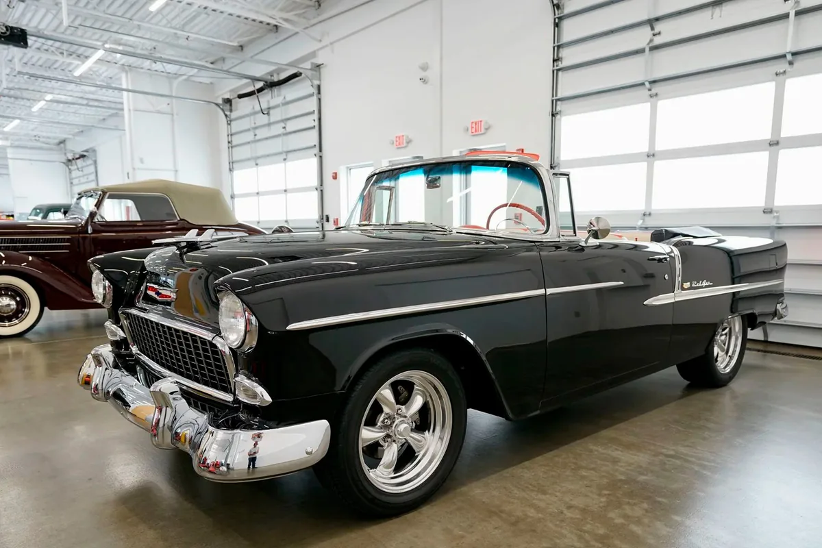 Black 1955 Chevrolet Bel Air convertible shown completely from a front three-quarter angle